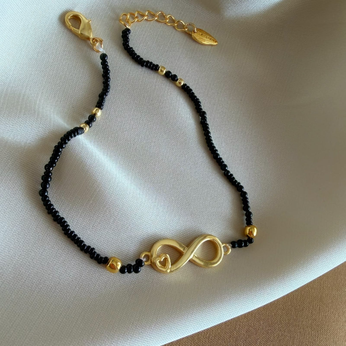 Amaltaas Infinite Love Black Onyx Anklet, handcrafted in 22k gold-plated brass